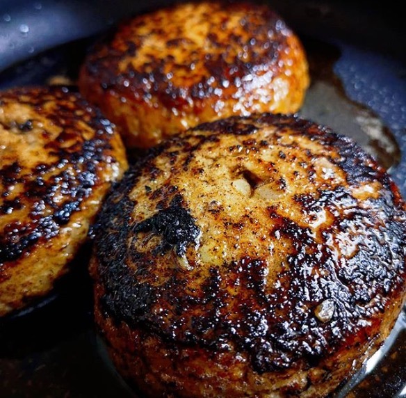 フライパンで焼き上がる三つのハンバーグ